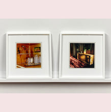 Load image into Gallery viewer, Light streams into the mid-century interior of the Harmony Motel, casting a patterned shadow across the rattan furniture and cactus. This cinematic motel room interior photograph taken in Twentynine Palms, California, is part of Richard Heeps' 'Dream in Colour' series.