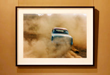 Load image into Gallery viewer, 'Mercury in the Dust I' shows a classic American car donut driving on a Norfolk beach in the East of England. This photograph was captured at Hemsby Rock and Roll weekend, and is part of Richard Heeps' Man's Ruin' series.