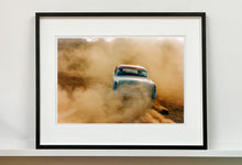 Load image into Gallery viewer, 'Mercury in the Dust I' shows a classic American car donut driving on a Norfolk beach in the East of England. This photograph was captured at Hemsby Rock and Roll weekend, and is part of Richard Heeps' Man's Ruin' series.