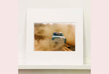 Load image into Gallery viewer, 'Mercury in the Dust I' shows a classic American car donut driving on a Norfolk beach in the East of England. This photograph was captured at Hemsby Rock and Roll weekend, and is part of Richard Heeps' Man's Ruin' series.