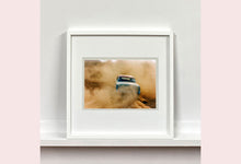 Load image into Gallery viewer, 'Mercury in the Dust I' shows a classic American car donut driving on a Norfolk beach in the East of England. This photograph was captured at Hemsby Rock and Roll weekend, and is part of Richard Heeps' Man's Ruin' series.