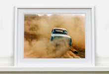 Load image into Gallery viewer, 'Mercury in the Dust I' shows a classic American car donut driving on a Norfolk beach in the East of England. This photograph was captured at Hemsby Rock and Roll weekend, and is part of Richard Heeps' Man's Ruin' series.