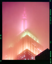 Load image into Gallery viewer, 'NOMAD III (Film Rebate)', New York. Richard Heeps has photographed the iconic Empire State building in the mist. The NOMAD sequence of photographs capture the art deco architecture illuminated by changing colours, and is part of Richard's street photography portfolio which depict the colour, fabric and structure of cities with distinct style. This 6x7 format edition is bordered by the Kodak film rebate.