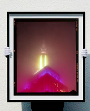 Load image into Gallery viewer, NOMAD VII (Film Rebate), New York, photography by Richard Heeps capturing the iconic Empire State building in the mist. Part of a sequence of photographs capturing the art deco architecture illuminated in changing colours. This 6x7 format edition is bordered by the Kodak film rebate. This artwork is part of Richard's portfolio of street photography he is building up which depict the colour, fabric and structure of cities with distinct style