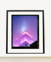 Load image into Gallery viewer, 'NOMAD VIII (Film Rebate)', New York. Richard Heeps has photographed the iconic Empire State building in the mist. The NOMAD sequence of photographs capture the art deco architecture illuminated by changing colours, and is part of Richard's street photography portfolio which depict the colour, fabric and structure of cities with distinct style. This 6x7 format edition is bordered by the Kodak film rebate. 