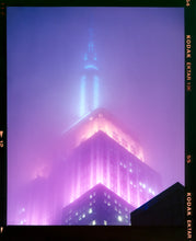 Load image into Gallery viewer, 'NOMAD VIII (Film Rebate)', New York. Richard Heeps has photographed the iconic Empire State building in the mist. The NOMAD sequence of photographs capture the art deco architecture illuminated by changing colours, and is part of Richard's street photography portfolio which depict the colour, fabric and structure of cities with distinct style. This 6x7 format edition is bordered by the Kodak film rebate. 
