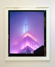 Load image into Gallery viewer, 'NOMAD VIII (Film Rebate)', New York. Richard Heeps has photographed the iconic Empire State building in the mist. The NOMAD sequence of photographs capture the art deco architecture illuminated by changing colours, and is part of Richard's street photography portfolio which depict the colour, fabric and structure of cities with distinct style. This 6x7 format edition is bordered by the Kodak film rebate. 