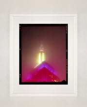 Load image into Gallery viewer, NOMAD VII (Film Rebate), New York, photography by Richard Heeps capturing the iconic Empire State building in the mist. Part of a sequence of photographs capturing the art deco architecture illuminated in changing colours. This 6x7 format edition is bordered by the Kodak film rebate. This artwork is part of Richard's portfolio of street photography he is building up which depict the colour, fabric and structure of cities with distinct style
