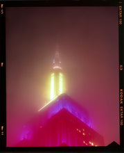 Load image into Gallery viewer, NOMAD VII (Film Rebate), New York, photography by Richard Heeps capturing the iconic Empire State building in the mist. Part of a sequence of photographs capturing the art deco architecture illuminated in changing colours. This 6x7 format edition is bordered by the Kodak film rebate. This artwork is part of Richard's portfolio of street photography he is building up which depict the colour, fabric and structure of cities with distinct style