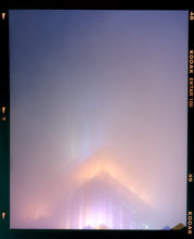 Load image into Gallery viewer, 'NOMAD VI (Film Rebate)', New York. Richard Heeps has photographed the iconic Empire State building in the mist. The NOMAD sequence of photographs capture the art deco architecture illuminated by changing colours, and is part of Richard's street photography portfolio which depict the colour, fabric and structure of cities with distinct style. This 6x7 format edition is bordered by the Kodak film rebate. 