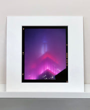 Load image into Gallery viewer, 'NOMAD V (Film Rebate)', New York. Richard Heeps has photographed the iconic Empire State building in the mist. The NOMAD sequence of photographs capture the art deco architecture illuminated by changing colours, and is part of Richard's street photography portfolio which depict the colour, fabric and structure of cities with distinct style. This 6x7 format edition is bordered by the Kodak film rebate. 