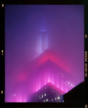 Load image into Gallery viewer, 'NOMAD V (Film Rebate)', New York. Richard Heeps has photographed the iconic Empire State building in the mist. The NOMAD sequence of photographs capture the art deco architecture illuminated by changing colours, and is part of Richard's street photography portfolio which depict the colour, fabric and structure of cities with distinct style. This 6x7 format edition is bordered by the Kodak film rebate. 