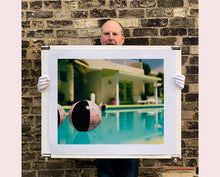 Load image into Gallery viewer, Part of Richard Heeps' 'Dream in Colour' Series, 'Beach Ball' captures Palm Springs mid-century modern architecture behind a trio of pink and black beach balls. The stillness and the subtle colours combine to make a calming artwork with a seductive cinematic vibe.
