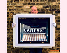 Load image into Gallery viewer, Cordial Campari, photographed as part of Richard Heeps’ series 'A Short History of Milan’ features beautiful and bold typography above the striped awning of a fascist building. 