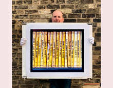 Load image into Gallery viewer, As part of Richard Heeps' series, A Short History of Milan, Delitto A Hollywood features a series of yellow Italian books from a street kiosk. 