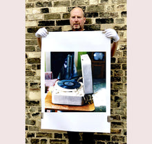 Load image into Gallery viewer, Disc Jockey, photographed by Richard Heeps at Preston Hall Museum, he was commissioned to photograph the museum before it went through regeneration. There is an air of nostalgia in the room of this interior photograph, featuring a retro table-top record player with a Decca vinyl record.