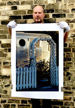 Load image into Gallery viewer, Part of Richard Heeps' 'Dream in Colour' series, this photograph features a white picket fence entrance to the Royal Mansion at the Shady Dell Trailer Park in Bisbee. Arizona. 