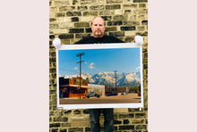 Load image into Gallery viewer, There is a cinematic style to this artwork, 'Lone Pine', taken in a former movie town in California where many Western films were made. Taken outside Richard's iconic interior photograph 'Bonanza Café', set in the Owens Valley against a mountainous  backdrop.