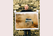 Load image into Gallery viewer, 'Mercury in the Dust I' shows a classic American car donut driving on a Norfolk beach in the East of England. This photograph was captured at Hemsby Rock and Roll weekend, and is part of Richard Heeps' Man's Ruin' series.