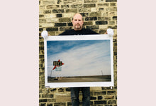 Load image into Gallery viewer, Part of the 'Dream in Colour' series, 'Roy's - Route 66' is one of Richard Heeps' classic American sign artworks featuring the road sign for Roy's Motel, which demonstrates historic Mid-Century Modern Googie architecture. This photograph was capture on the National Trails Highway of U.S. Route 66, in the Mojave Desert town of Amboy in San Bernardino County, California.
