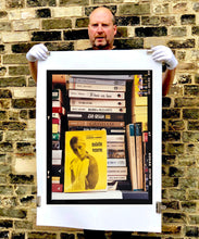 Load image into Gallery viewer, ‘Scientific Sexology’ sits amongst a stack of books, captured in Milan, Italy. 
