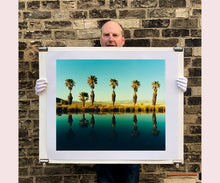 Load image into Gallery viewer, Plam trees stand tall against ombre skies in shades of blue and green in 'Zzyzx Resort Pool II', taken in Soda Dry Lake, California. This artwork was taken on a road trip from LA to Las Vegas. This photograph was taken on negative in 2002 but only executed in Richard's darkroom for the first time in 2017.