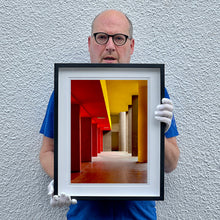 Load image into Gallery viewer, Monte Amiata housing, Gallaratese Quarter, Milan. Red and yellow brutalist architecture street photography by Richard Heeps framed in black.