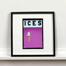 Load image into Gallery viewer, Black framed photograph by Richard Heeps.  At the top black letters spell out ICES and below is depicted a 99 icecream cone sitting left of centre against a plum coloured background.  