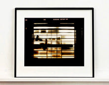 Load image into Gallery viewer, Silhouettes seen through a shop window in Milan. 