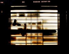 Load image into Gallery viewer, Silhouettes seen through a shop window in Milan. 