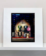 Load image into Gallery viewer, The traditional Italian Tobacconist shop, here in a Swiss Cottage style building set against a vast urban apartment block.