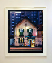 Load image into Gallery viewer, The traditional Italian Tobacconist shop, here in a Swiss Cottage style building set against a vast urban apartment block. 
