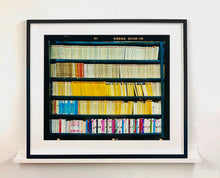 Load image into Gallery viewer, As part of Richard Heeps' series, A Short History of Milan, The Last Kiss features a series of yellow, blue and pink Italian books.