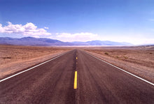 Load image into Gallery viewer, 'The Road to Death Valley', taken in the Majove Desert, California, features a clouded blue sky met my mountains on the horizon. This American landscape artwork is part of Richard Heeps' 'Dream in Colour' series. Taken in 2001, this artwork was first executed in Richard's darkroom in 2021.