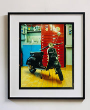 Load image into Gallery viewer, A black vespa against a red, blue and yellow interior. Photographed in Milan, Italy. 