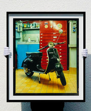 Load image into Gallery viewer, A black vespa against a red, blue and yellow interior. Photographed in Milan, Italy. 
