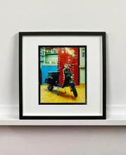 Load image into Gallery viewer, A black vespa against a red, blue and yellow interior. Photographed in Milan, Italy. 