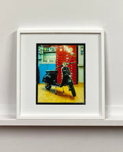Load image into Gallery viewer, A black vespa against a red, blue and yellow interior. Photographed in Milan, Italy. 