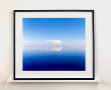 Load image into Gallery viewer, 'View from Bombay Beach' looks over Salton Sea in California. Cooling shades of blue, reflection and symmetry are key to this serene waterscape. The suspended cloud which looks surreal creates a feeling of weightlessness. 