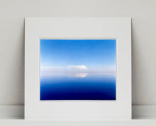 Load image into Gallery viewer, 'View from Bombay Beach' looks over Salton Sea in California. Cooling shades of blue, reflection and symmetry are key to this serene waterscape. The suspended cloud which looks surreal creates a feeling of weightlessness. 