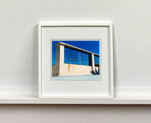 Load image into Gallery viewer, 'Window of the World, Zzyzx Resort Pool', photographed in Soda Dry Lake, California shows window pains and a distressed wall, against a bright blue background of sky. This artwork is part of Richard's 'Dream in Colour' series. 