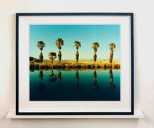 Load image into Gallery viewer, Plam trees stand tall against ombre skies in shades of blue and green in 'Zzyzx Resort Pool II', taken in Soda Dry Lake, California. This artwork was taken on a road trip from LA to Las Vegas. This photograph was taken on negative in 2002 but only executed in Richard's darkroom for the first time in 2017.