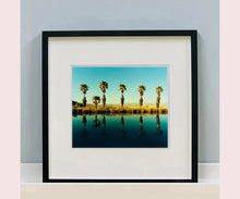 Load image into Gallery viewer, Plam trees stand tall against ombre skies in shades of blue and green in 'Zzyzx Resort Pool II', taken in Soda Dry Lake, California. This artwork was taken on a road trip from LA to Las Vegas. This photograph was taken on negative in 2002 but only executed in Richard's darkroom for the first time in 2017.