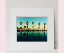 Load image into Gallery viewer, Plam trees stand tall against ombre skies in shades of blue and green in 'Zzyzx Resort Pool II', taken in Soda Dry Lake, California. This artwork was taken on a road trip from LA to Las Vegas. This photograph was taken on negative in 2002 but only executed in Richard's darkroom for the first time in 2017.