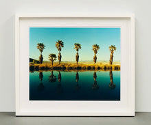 Load image into Gallery viewer, Plam trees stand tall against ombre skies in shades of blue and green in 'Zzyzx Resort Pool II', taken in Soda Dry Lake, California. This artwork was taken on a road trip from LA to Las Vegas. This photograph was taken on negative in 2002 but only executed in Richard's darkroom for the first time in 2017.