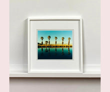 Load image into Gallery viewer, Plam trees stand tall against ombre skies in shades of blue and green in 'Zzyzx Resort Pool II', taken in Soda Dry Lake, California. This artwork was taken on a road trip from LA to Las Vegas. This photograph was taken on negative in 2002 but only executed in Richard's darkroom for the first time in 2017.