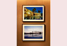 Load image into Gallery viewer, Zzyzx Resort Pool, part of Richard Heeps 'Dream in Colour' Series, he was set a challenge to find something interesting on the road from LA to Las Vegas. In the heart of the Mojave Desert, Richard found the former spa Zzyzx, an oasis. This dreamy artwork keeps the perfect summery palm print vibe all year round.